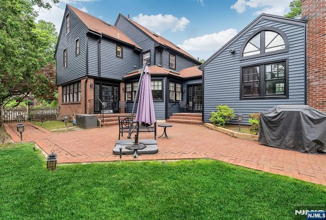 518 Standish Rd, Teaneck, NJ 07666 - rear view of property featuring a lawn, a patio area, and brick siding