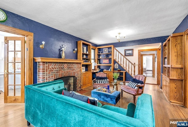 518 Standish Rd, Teaneck, NJ 07666 - living area with a textured ceiling, a textured wall, wood finished floors, a fireplace, and stairway