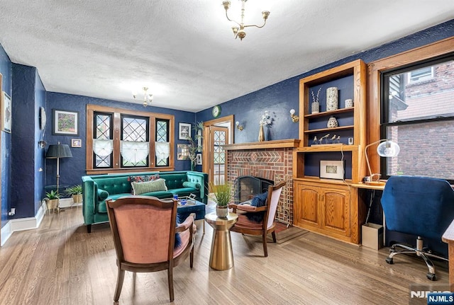518 Standish Rd, Teaneck, NJ 07666 - living room featuring a textured ceiling, wood finished floors, an office area, a brick fireplace, and a textured wall