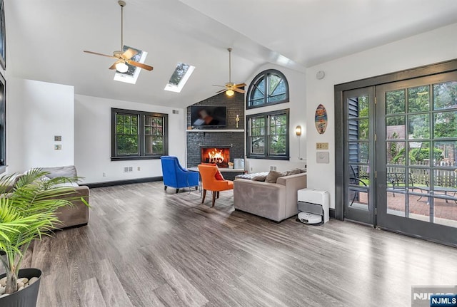 518 Standish Rd, Teaneck, NJ 07666 - living room with a ceiling fan, a fireplace, wood finished floors, a skylight, and high vaulted ceiling