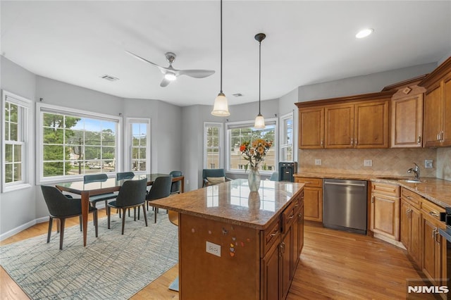 87 Centre St Unit 2, Nutley, NJ 07110 - kitchen featuring stainless steel dishwasher, ceiling fan, light wood finished floors, backsplash, and brown cabinetry