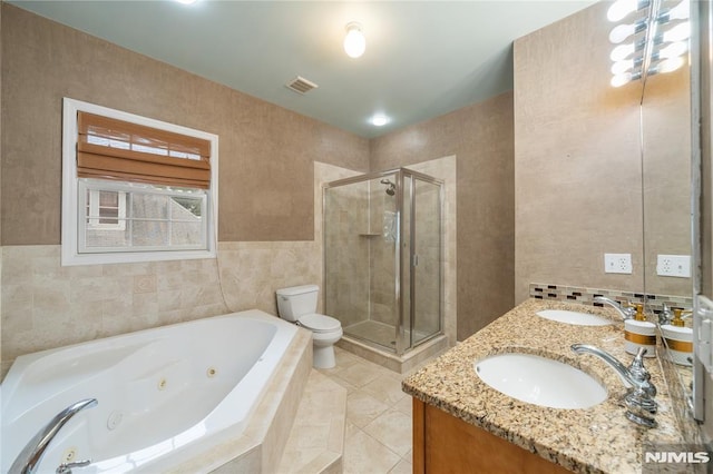 87 Centre St Unit 2, Nutley, NJ 07110 - bathroom with a jetted tub, a shower stall, double vanity, tile patterned flooring, and tile walls
