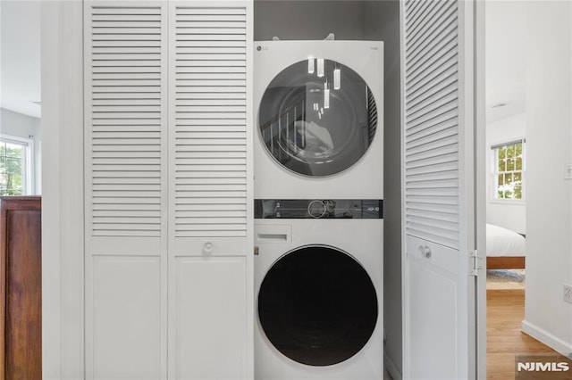 87 Centre St Unit 2, Nutley, NJ 07110 - laundry room featuring stacked washer / dryer and wood finished floors