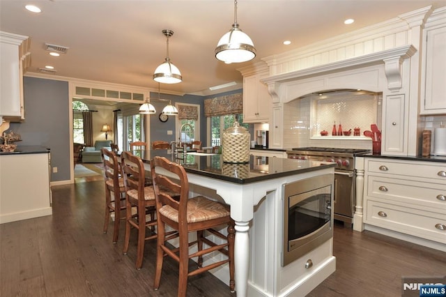 581 Eder Ave, Wyckoff, NJ 07481 - kitchen featuring stainless steel appliances, dark countertops, ornamental molding, decorative backsplash, and a breakfast bar area