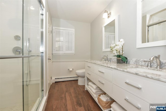 581 Eder Ave, Wyckoff, NJ 07481 - full bathroom with a baseboard radiator, wood finished floors, double vanity, a wainscoted wall, and a stall shower