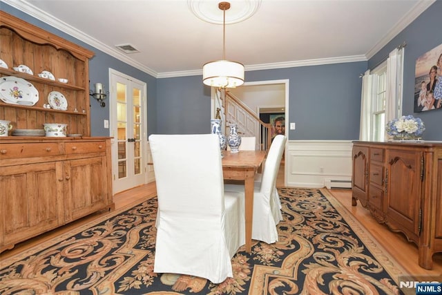 581 Eder Ave, Wyckoff, NJ 07481 - dining area featuring light wood-type flooring, crown molding, french doors, a wainscoted wall, and stairs