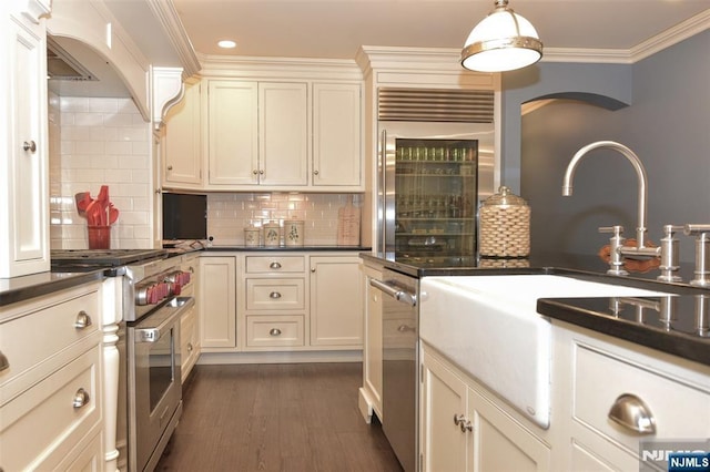 581 Eder Ave, Wyckoff, NJ 07481 - kitchen featuring premium appliances, wine cooler, arched walkways, dark countertops, and decorative backsplash
