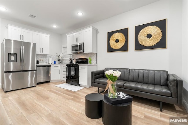 36 Kent, Newark, NJ 07108 - kitchen featuring stainless steel appliances, white cabinetry, tasteful backsplash, light wood-style floors, and recessed lighting