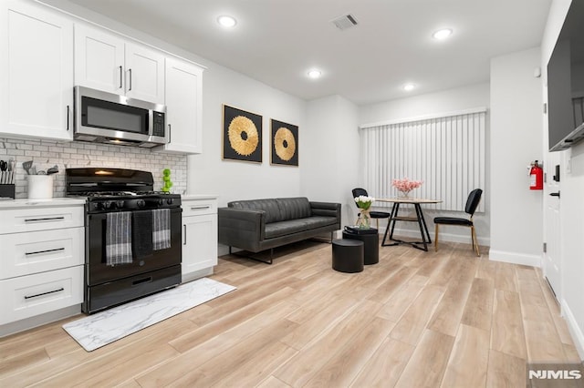 36 Kent, Newark, NJ 07108 - kitchen featuring stainless steel microwave, black gas stove, backsplash, light countertops, and recessed lighting