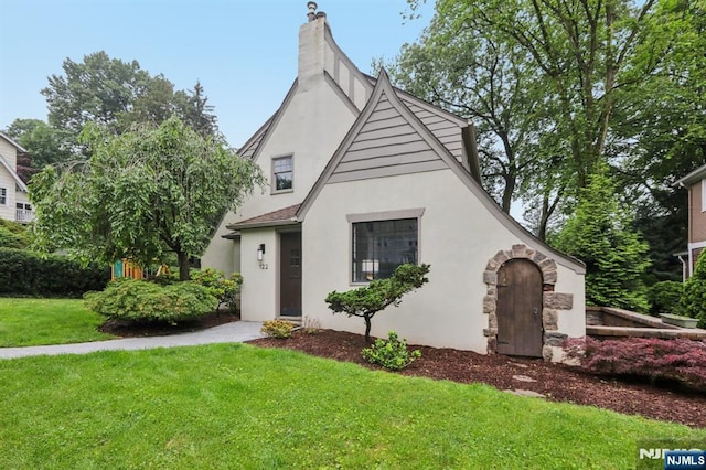 122 Howard Ter, Leonia, NJ 07605 - tudor house with stucco siding, a front yard, and a chimney