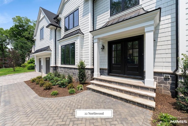 22 Northwood Ave, Demarest, NJ 07627 - property entrance featuring french doors, a standing seam roof, a garage, decorative driveway, and a metal roof