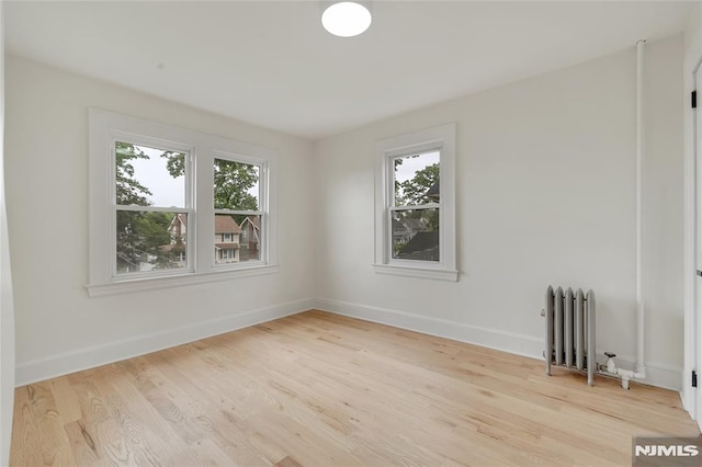 115 Wilson Ave, Rutherford, NJ 07070 - empty room featuring radiator heating unit, healthy amount of natural light, and wood finished floors