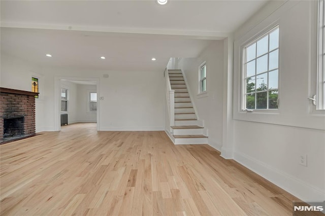 115 Wilson Ave, Rutherford, NJ 07070 - unfurnished living room featuring light wood-type flooring, stairs, a brick fireplace, and recessed lighting