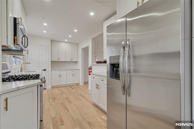 115 Wilson Ave, Rutherford, NJ 07070 - kitchen with stainless steel appliances, light wood-style flooring, white cabinets, recessed lighting, and light stone countertops