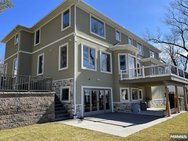 275 Gorden Dr, Paramus, NJ 07652 - rear view of house featuring stone siding, stucco siding, a patio, and a yard