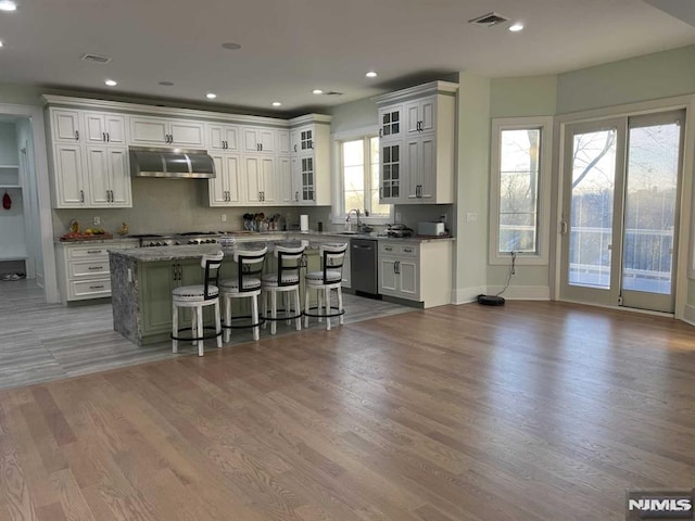 275 Gorden Dr, Paramus, NJ 07652 - kitchen featuring extractor fan, dishwashing machine, a breakfast bar, a center island, and wood finished floors