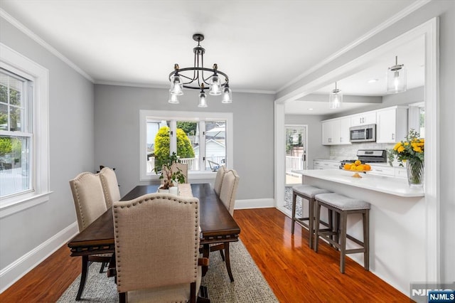 188 Wheaton Pl, Rutherford, NJ 07070 - dining room with dark wood-style flooring, healthy amount of natural light, ornamental molding, and a chandelier