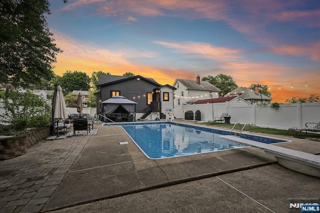21 Mountainview Ave, Nutley, NJ 07110 - pool at dusk with a gazebo, a patio, a diving board, and a fenced backyard