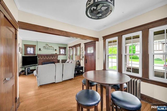 74 Bartholdi Ave, Butler Borough, NJ 07405 - dining area with radiator heating unit, light wood finished floors, ornamental molding, and a brick fireplace