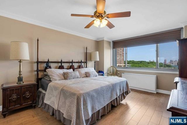 1600 Parker Ave Unit 1G, Fort Lee, NJ 07024 - bedroom featuring light wood-style floors, radiator heating unit, ornamental molding, and a ceiling fan