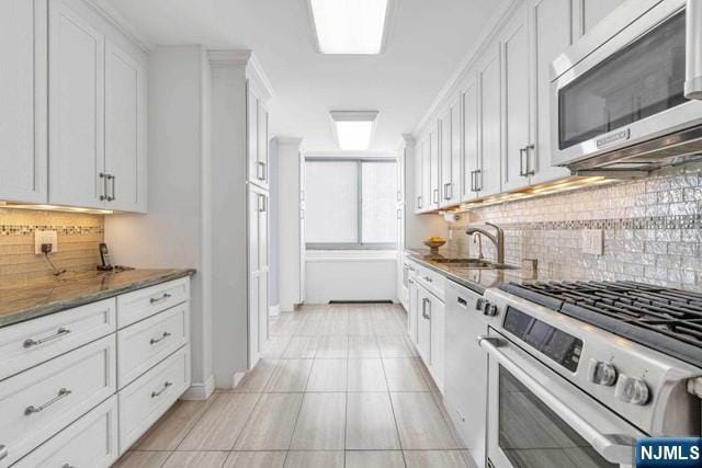 1600 Parker Ave Unit 1G, Fort Lee, NJ 07024 - kitchen with stainless steel appliances, dark stone countertops, tasteful backsplash, light tile patterned floors, and white cabinetry