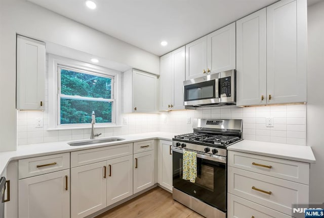 97 Palisade Ave, Leonia, NJ 07605 - kitchen featuring appliances with stainless steel finishes, light wood finished floors, white cabinets, light countertops, and recessed lighting