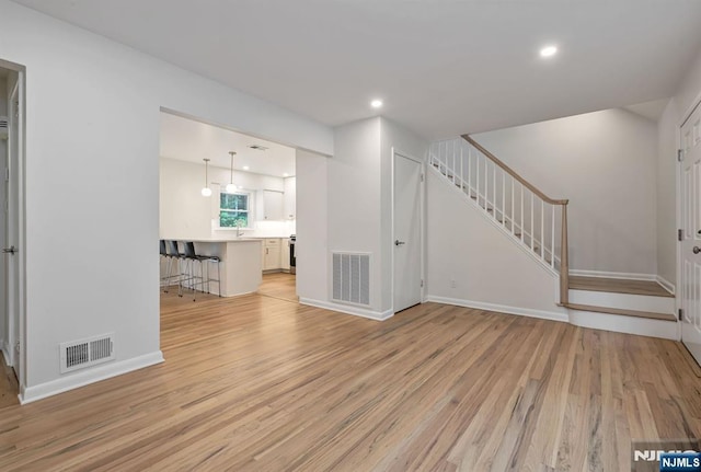 97 Palisade Ave, Leonia, NJ 07605 - unfurnished living room with stairway, light wood finished floors, and recessed lighting