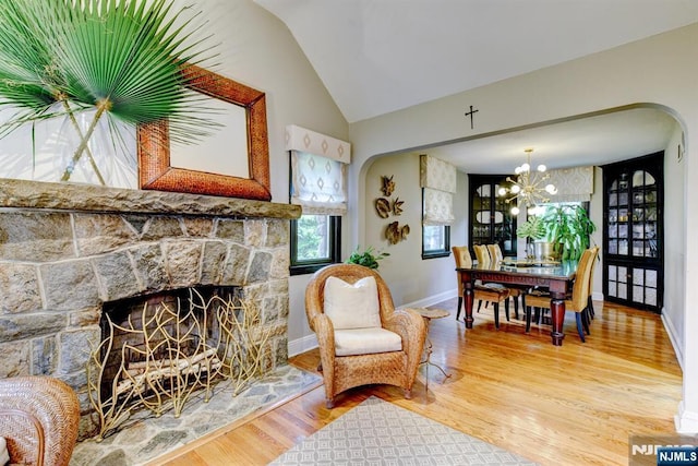 99 Chestnut Dr, Wayne, NJ 07470 - living room featuring a fireplace, arched walkways, wood finished floors, lofted ceiling, and a chandelier