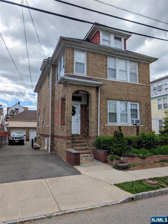 138 Chestnut St, West Orange, NJ 07052 - view of front facade featuring brick siding, an outbuilding, and cooling unit