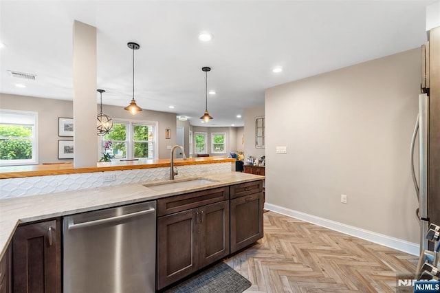37 Golf Ct, Teaneck, NJ 07666 - kitchen with stainless steel appliances, dark brown cabinetry, light stone counters, hanging light fixtures, and recessed lighting