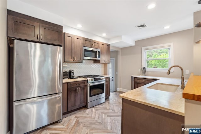37 Golf Ct, Teaneck, NJ 07666 - kitchen featuring appliances with stainless steel finishes, a peninsula, decorative backsplash, dark brown cabinetry, and recessed lighting
