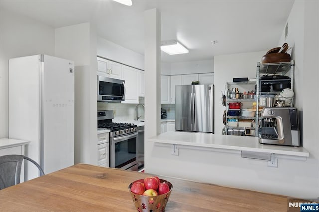 223 Orchard Park, Allendale, NJ 07401 - kitchen featuring appliances with stainless steel finishes, white cabinetry, tasteful backsplash, and light countertops