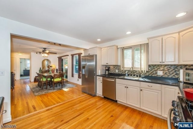362 Valley Rd, Wayne, NJ 07470 - kitchen with stainless steel appliances, light wood-style floors, backsplash, dark countertops, and recessed lighting