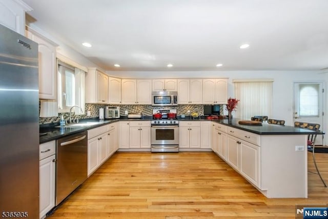 362 Valley Rd, Wayne, NJ 07470 - kitchen featuring stainless steel appliances, a peninsula, tasteful backsplash, light wood-type flooring, and recessed lighting