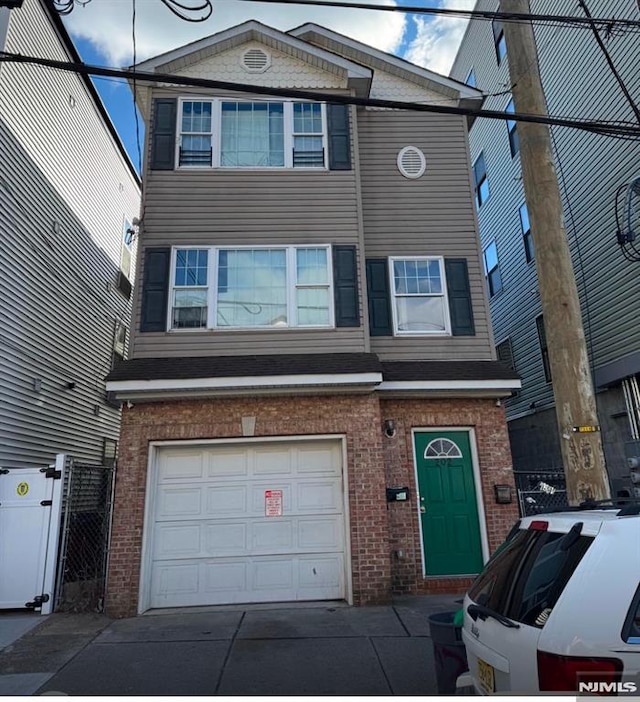 202 Harrison St, Paterson, NJ 07501 - view of front of house featuring a garage, brick siding, and a gate