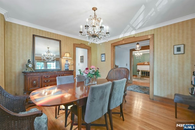 116 Sherman Ave, Teaneck, NJ 07666 - dining space with a chandelier, wallpapered walls, light wood finished floors, and ornamental molding