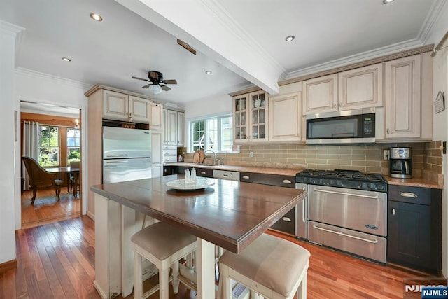 116 Sherman Ave, Teaneck, NJ 07666 - kitchen with appliances with stainless steel finishes, backsplash, ceiling fan, light wood-style flooring, and crown molding