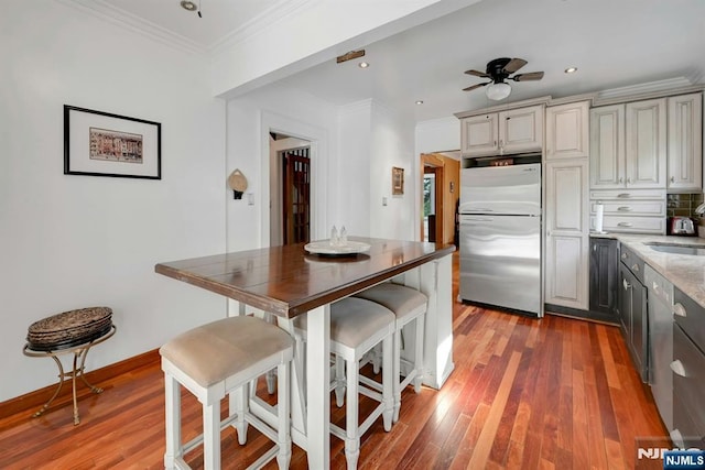 116 Sherman Ave, Teaneck, NJ 07666 - kitchen with freestanding refrigerator, light wood-style floors, a kitchen bar, recessed lighting, and ornamental molding