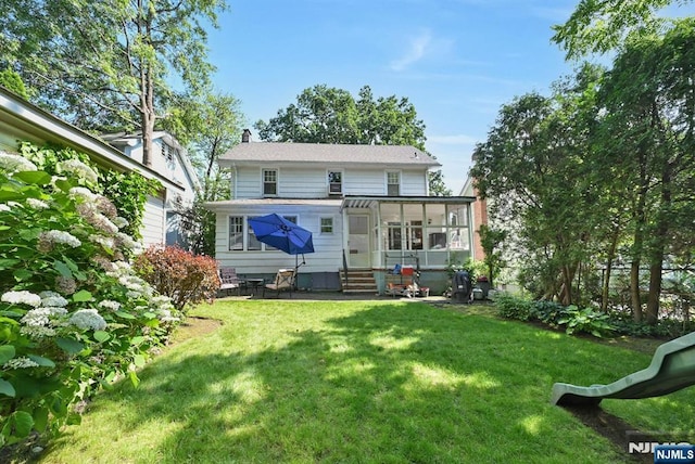 116 Sherman Ave, Teaneck, NJ 07666 - rear view of house with entry steps, a lawn, a chimney, and a sunroom