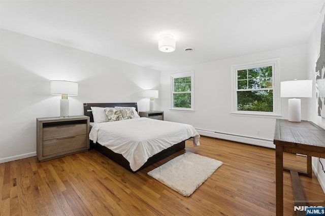 890 Ridgewood Ave, Oradell, NJ 07649 - bedroom featuring a baseboard radiator and wood finished floors