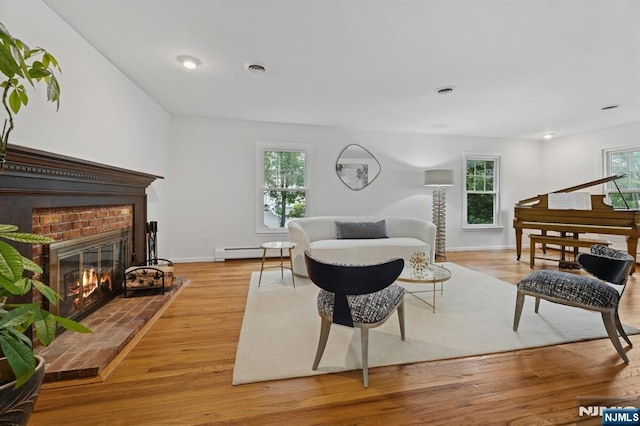 890 Ridgewood Ave, Oradell, NJ 07649 - living room featuring a baseboard heating unit, a brick fireplace, and wood finished floors