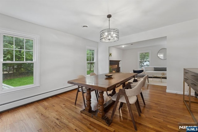 890 Ridgewood Ave, Oradell, NJ 07649 - dining room with a baseboard heating unit, healthy amount of natural light, a chandelier, and light wood finished floors