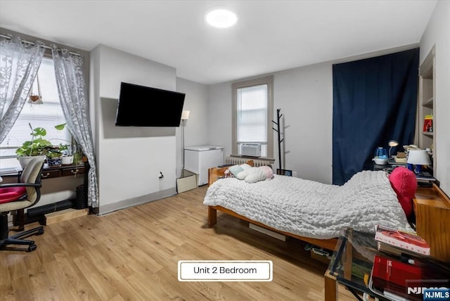 87 James St, Englewood, NJ 07631 - bedroom featuring wood finished floors, radiator heating unit, and an office area