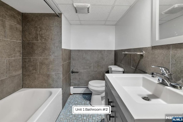 87 James St, Englewood, NJ 07631 - full bathroom with a baseboard heating unit, tile walls, vanity, tile patterned flooring, and a drop ceiling