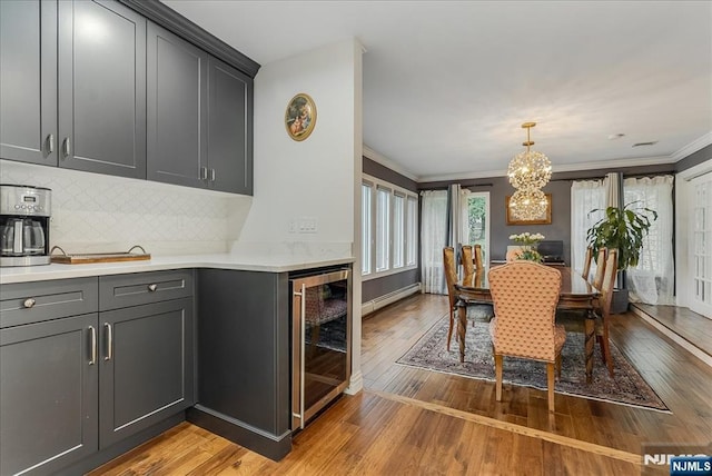 8 Oratam Rd, Upper Saddle River, NJ 07458 - dining room featuring wine cooler, light wood-style floors, a chandelier, and ornamental molding