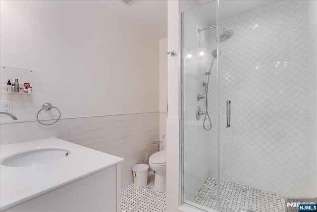 8 Oratam Rd, Upper Saddle River, NJ 07458 - bathroom featuring tile walls, a shower stall, vanity, and wainscoting