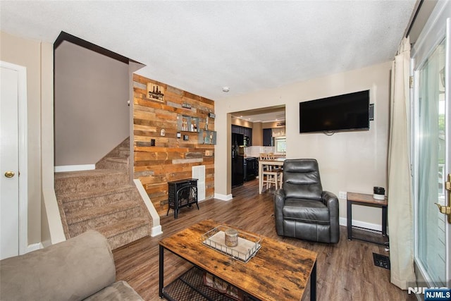 15 Mason St, Jefferson Township, NJ 07849 - living area featuring wood finished floors, a textured ceiling, stairs, wood walls, and a wood stove