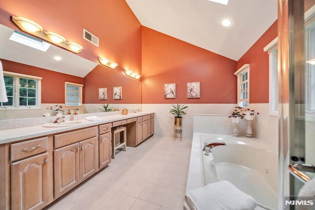 12 Jenny Ln, Wayne, NJ 07470 - full bathroom with a skylight, double vanity, a garden tub, tile patterned floors, and tile walls
