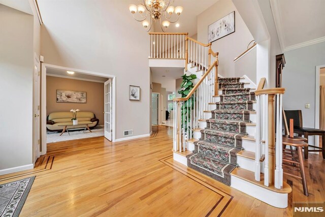 12 Jenny Ln, Wayne, NJ 07470 - stairs featuring wood finished floors, a high ceiling, ornamental molding, and a chandelier