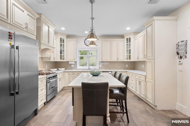 66 Andover Ter, Glen Rock, NJ 07452 - kitchen with appliances with stainless steel finishes, light countertops, a center island, pendant lighting, and recessed lighting